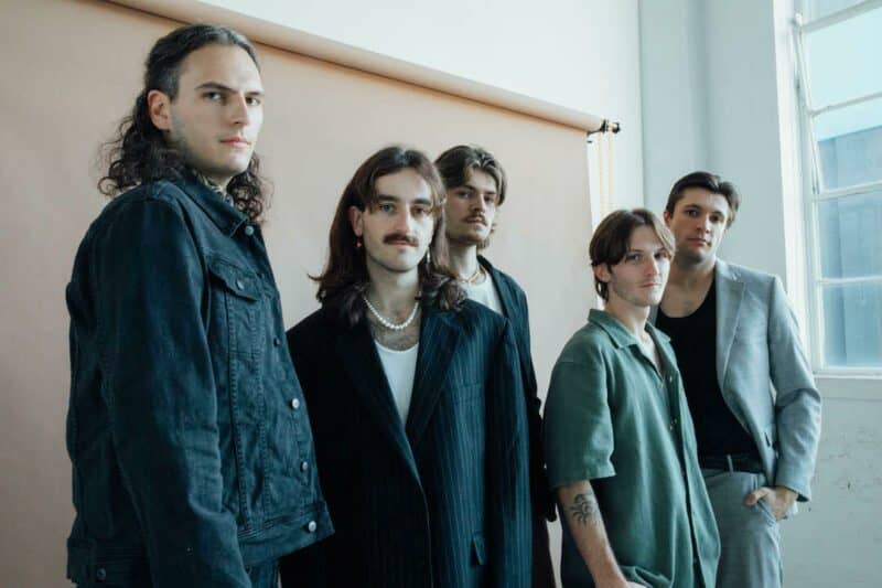 Pastures Press Photo, with all 5 band members standing and looking into the camera.